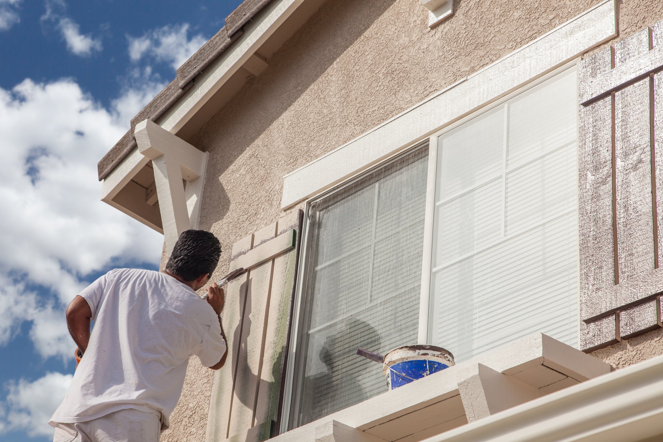 Professional House Painter Painting The Trim And Shutters